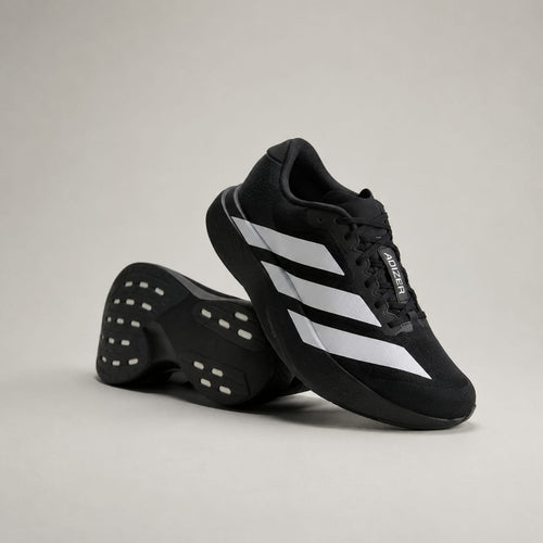 A pair of black Adidas running shoes with signature white three-stripes, shown on a neutral light gray studio background.