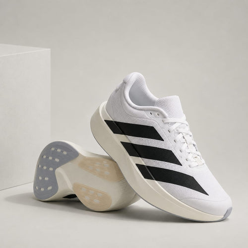 A pair of white Adidas running shoes with black three-stripes, shown on a light gray studio background with one shoe standing upright and the other lying on its side to display the sole.